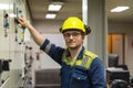 Young marine engineer in front of control panel during his daily routine work in engine room. Seafarers life. Royalty Free Stock Photo