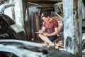 young male mechanic sitting while writing a list of car repairs