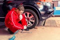 Young male motor mechanic checking the air pressure of a tyre Royalty Free Stock Photo