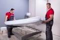 Young Male Movers Placing The Mattress Over The Bed Royalty Free Stock Photo