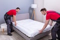 Young Male Movers Placing The Mattress Over The Bed Royalty Free Stock Photo