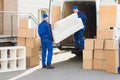 Movers Unloading Sofa From Truck