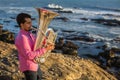 Young male musician playing trumpet on the sea coast. Hobby. Royalty Free Stock Photo