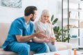 young male nurse showing medicine to senior woman