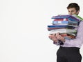 Young Male Office Worker Carrying Heavy Binders