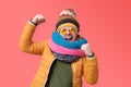 Young male in orange summer glasses and winter scarf clenches fists in joy, like a winner Royalty Free Stock Photo