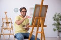 Young man enjoying painting at home