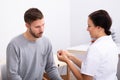 Man Looking At Doctor Holding Hearing Aid Royalty Free Stock Photo