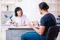 Young male patient visiting aged female doctor Royalty Free Stock Photo