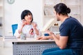 Young male patient visiting aged female doctor Royalty Free Stock Photo