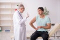 Young male patient visiting old male doctor in vaccination conce Royalty Free Stock Photo