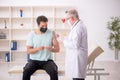 Young male patient visiting old male doctor in vaccination conce Royalty Free Stock Photo