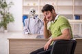 Young male patient visiting skeleton doctor Royalty Free Stock Photo