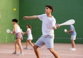 Young male pelota player hitting ball with wooden racket Royalty Free Stock Photo