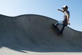 Young male performing skateboarding at an outdoor skateboard park