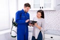 Pest Control Worker Showing Invoice To Woman