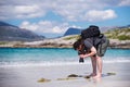 Young male photographer with dreadlocks at a sunny white sand beach, Luskentyre, Isle of Harris, Hebrides, Scotland