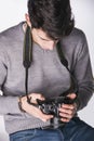 Young male photographer looking at photographs on his photocamera