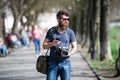 Young male photographer stroll around city in search for perfect picture. Bearded man in stylish eyewear holding vintage Royalty Free Stock Photo