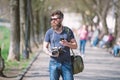 Young male photographer stroll around city in search for perfect picture. Bearded man in stylish eyewear holding vintage Royalty Free Stock Photo
