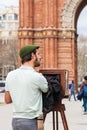 Young male photographer taking pictures using a vintage wooden camera