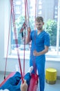 Young male physician in rehabilitation room near lying patient