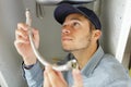 young male plumber fitting flexible pipe under sink Royalty Free Stock Photo