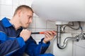 Male Plumber Fixing Sink In Bathroom Royalty Free Stock Photo