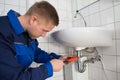 Male Plumber Fixing Sink In Bathroom Royalty Free Stock Photo