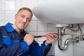Male Plumber Fixing Sink In Bathroom Royalty Free Stock Photo