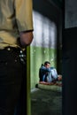 Young male prisoner sitting alone in an obsolete prison cell Royalty Free Stock Photo