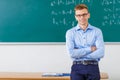 Young male professor is posing at the desk