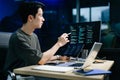Young male programmer working with tablet and screen displaying code. Modern tech office setup, great for software, coding, IT Royalty Free Stock Photo
