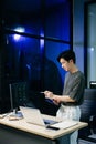 Young male programmer working with tablet and screen displaying code. Modern tech office setup, great for software, coding, IT Royalty Free Stock Photo