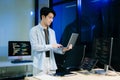 Young male programmer working with tablet and screen displaying code. Modern tech office setup, great for software Royalty Free Stock Photo