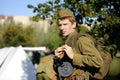 Young male reenactor dressed in uniform of Red Army soldiers of World War II holding retro machine gun