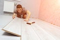 Young male repairman is laying panel of laminate floor indoors. Royalty Free Stock Photo