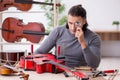 Young male repairman repairing guitar Royalty Free Stock Photo