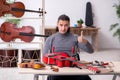 Young male repairman repairing guitar Royalty Free Stock Photo