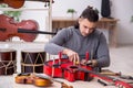 Young male repairman repairing guitar Royalty Free Stock Photo