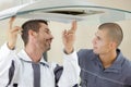 Young male repairmen fixing kitchen extractor filter