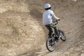 Young male riding a bicycle in a brown field Royalty Free Stock Photo