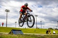 Young male riding a bicycle mid-air, with the handlebars raised above his head in a jump Royalty Free Stock Photo