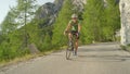 Young male road cyclist having fun pedalling his bike up a steep asphalt road. Royalty Free Stock Photo