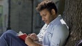 Young male romantic plunged with head into world of printed word, reading book