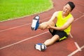 Young male runner suffering from leg cramp on the track