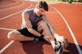 Young male runner suffering from leg cramp on the track Royalty Free Stock Photo