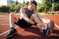 Young male runner suffering from leg cramp on the track Royalty Free Stock Photo
