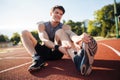 Young male runner suffering from leg cramp on the track Royalty Free Stock Photo