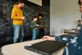 Center For Excellence. Young male science teacher standing near the blackboard, holding tablet pc and looking at his